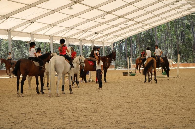 jovenes montanado a caballo en el campamento de verano en portugal