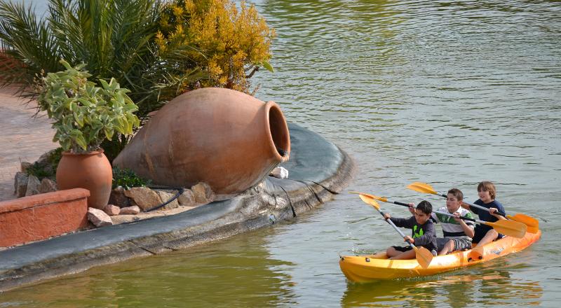 carrera de kayak por el lago de los niños que participan en el campamento de verano en Alicante