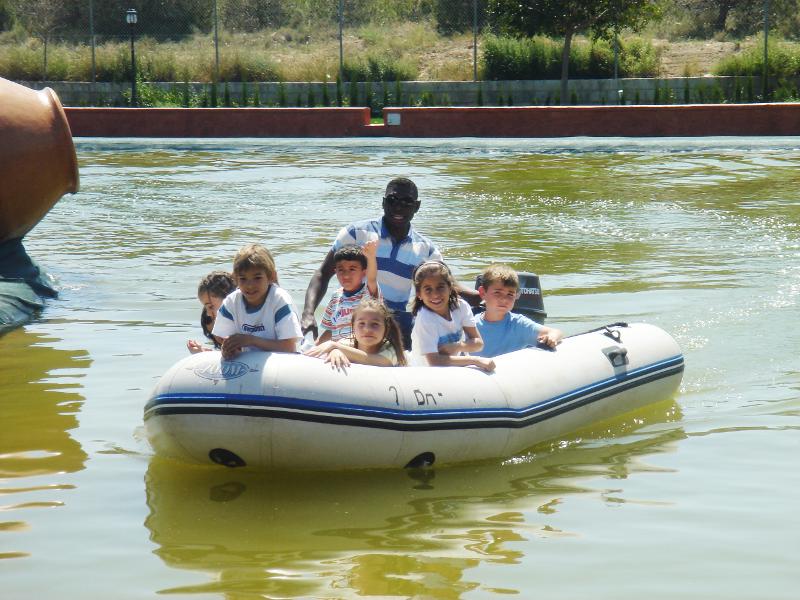 niños navegando con la barca por el lago del campamento ingles zaragoza