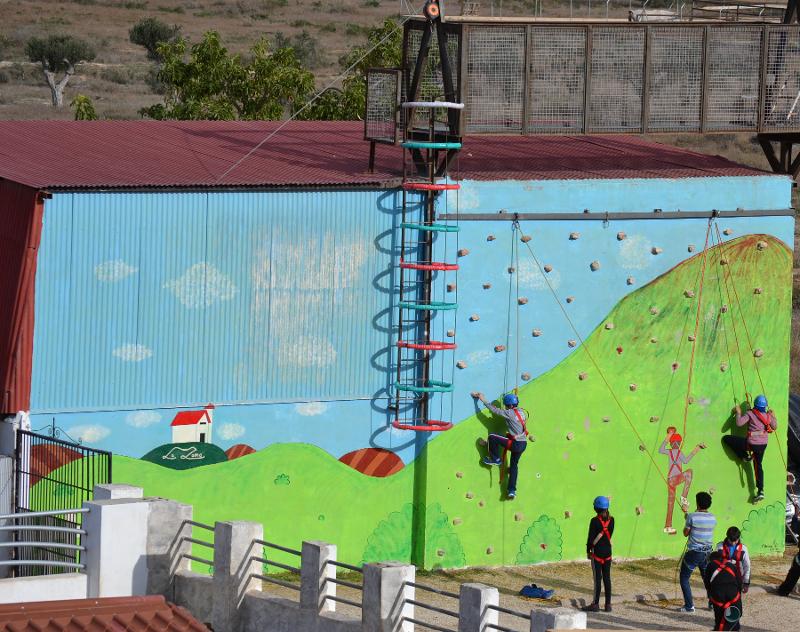 Niños realizando escalada en el campamento de verano en Alicante