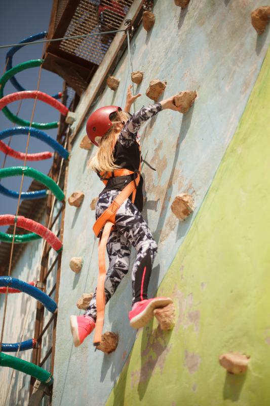 Niña haciendo escalada en el rocódromo en las vacaciones para niños españa
