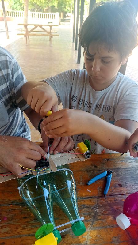 Chico construyendo un robot en el campamento verano alicante