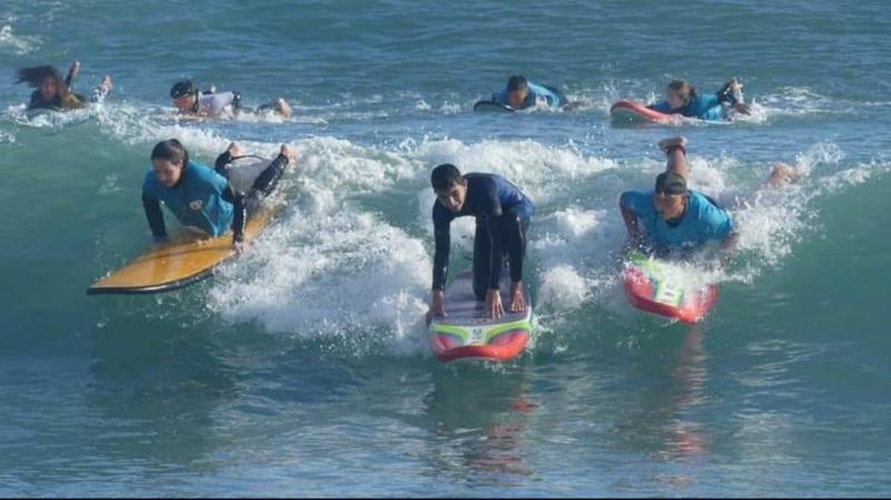 Grupo de campistas surfeando en el campamento verano alicante