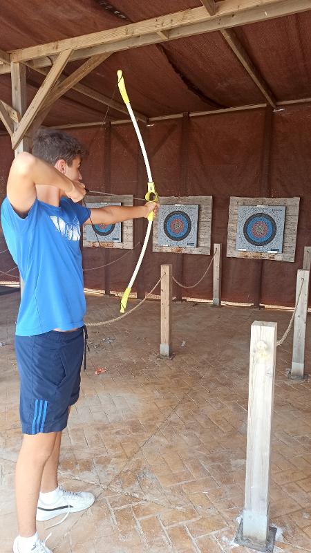 Chico haciendo tiro al arco en el campamento verano alicante