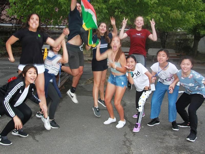 Grupo de jóvenes saltando y riéndose en el curso frances en francia verano 