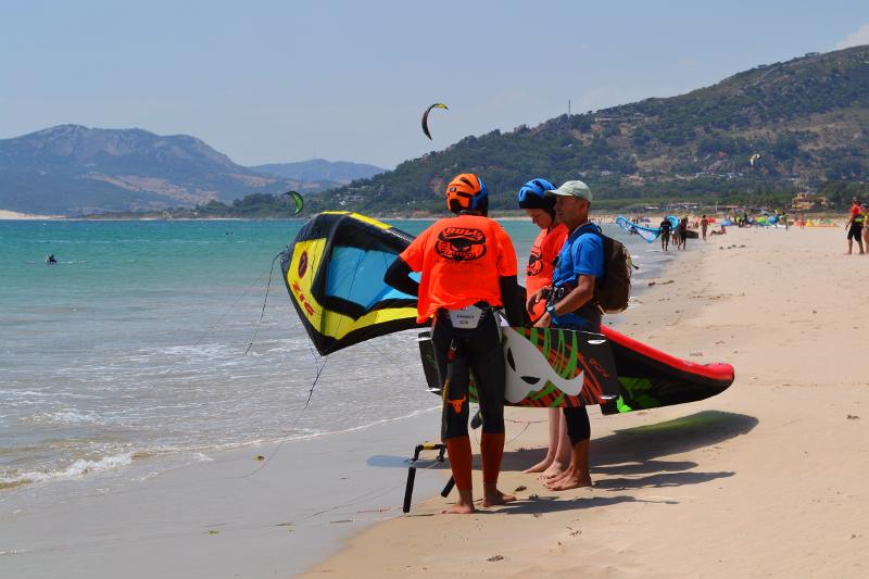 joven practicando kitesurf en la playa con muchas olas durante las clases del campamento de verano inglés en España