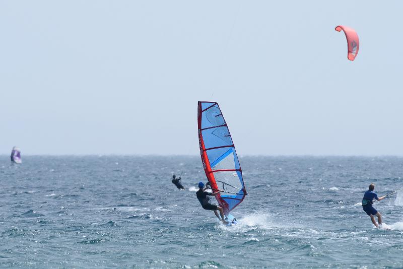 Jóvenes surcando las olas en el campamento de verano en Cádiz