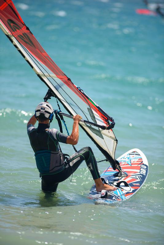 Joven practicando en su tabla en el mar en el campamento de verano en Cádiz