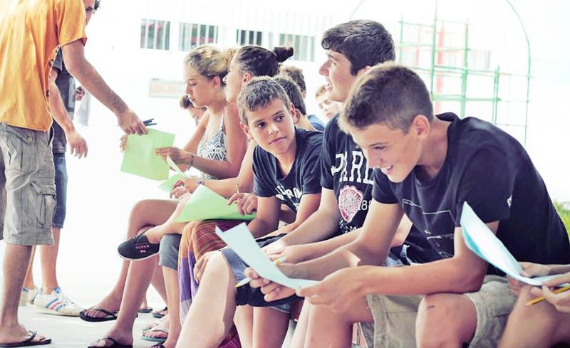 Chicos revisando sus deberes en las clases teóricas en el campamento de verano en Cádiz
