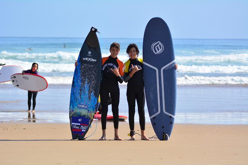 niños posando con sus tablas en la orilla de la playa donde se practican las clases del campamento surf Francia