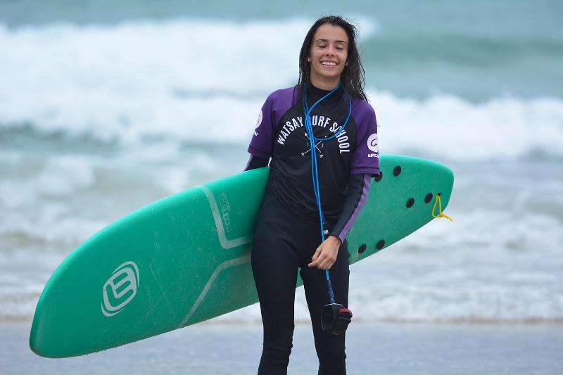 niña feliz después de haber hecho surf y aguantado en el campamento de verano en Cantabria