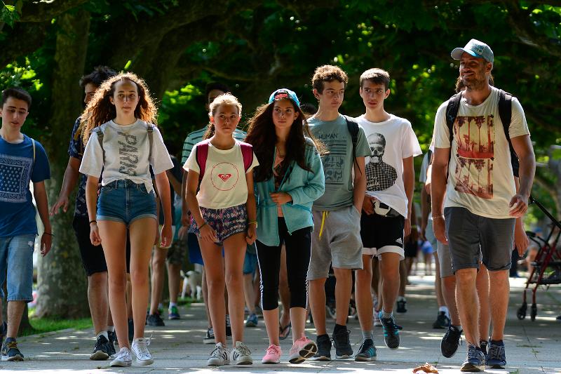 Grupo de jóvenes caminando al aire libre en una de las excursiones del campamento de surf en Cantabria
