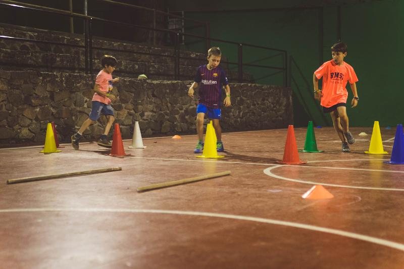 Niños participando en los juegos de obstaculos del campamento de verano en tarragona