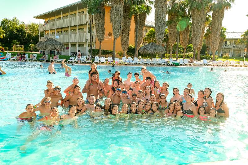 Grupo de jóvenes disfrutando de la piscina del hotel en el campamento de verano en Cáceres