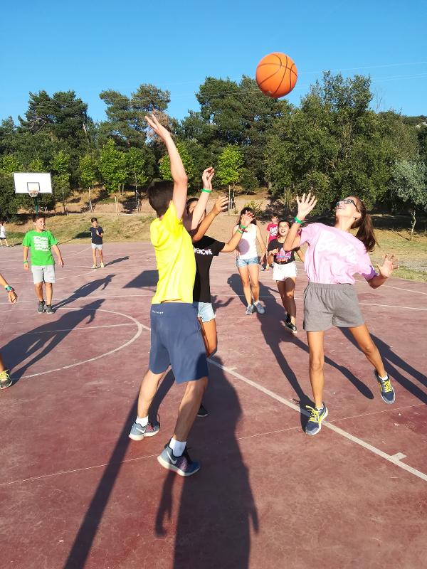 grupo de niños jugando un partido de baloncesto en el campamento de verano en tarragona