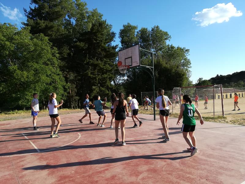 Grupo de niños jugando un partido de baloncesto durante el campamento de verano en tarragona