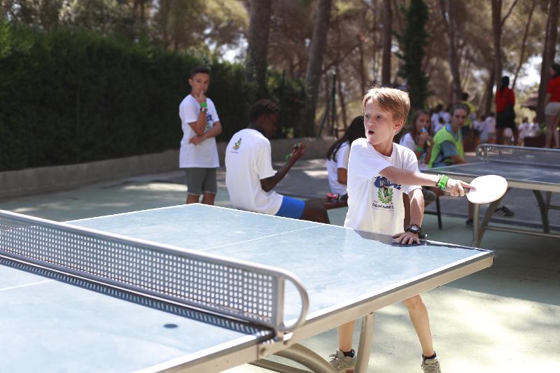 Niños jugando al ping pong en las instalaciones del campamento de verano en tarragona