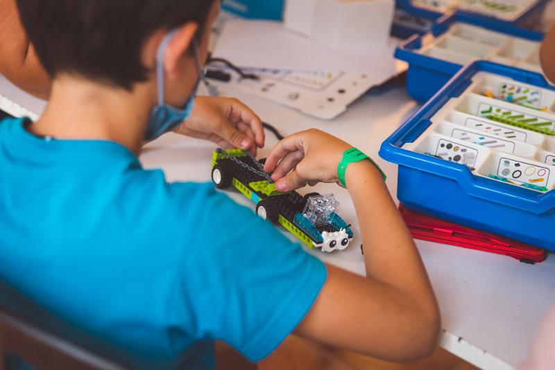 Niño feliz con los instrumentos tecnológicos del campamento de verano en Tarragona