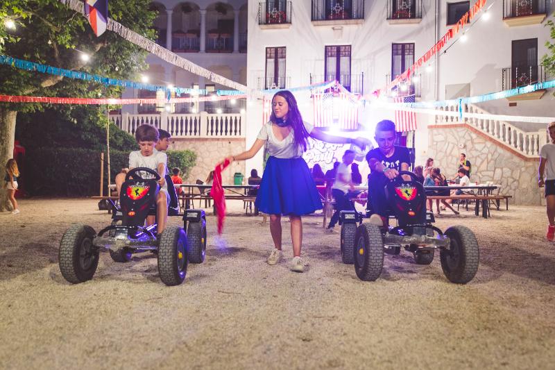Niños realizando una carrera de quads de pedales en las veladas nocturnas del campamento de verano en tarragona