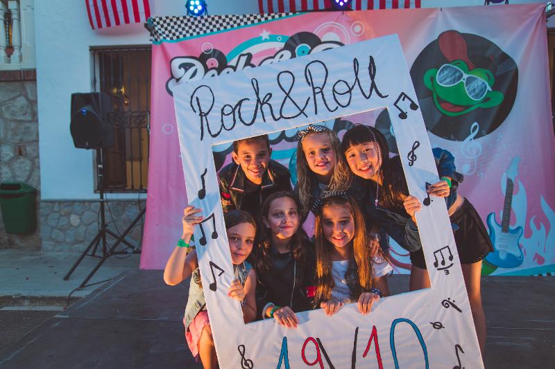 grupo de niños posando con un photo call de rock en el campamento de musica en tarragona