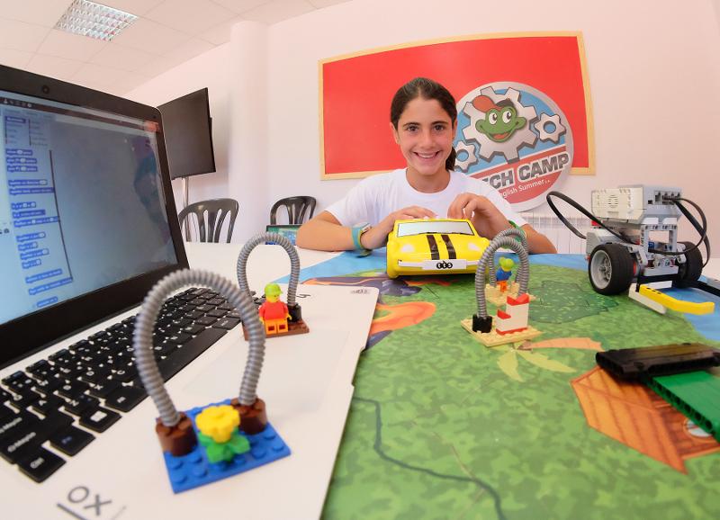 Niña realizando un interesante proyecto durante un campamento de verano tecnologico