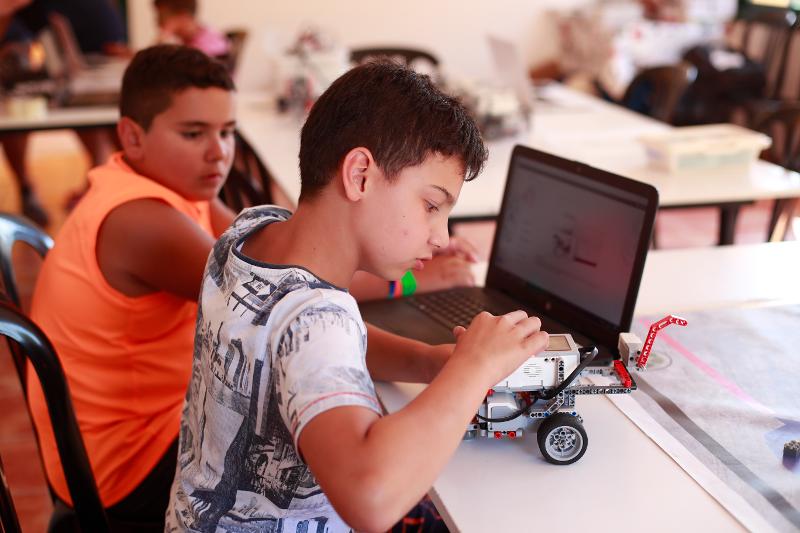 Niño realizando el proyecto de un coche durante un campamento de verano tecnologico