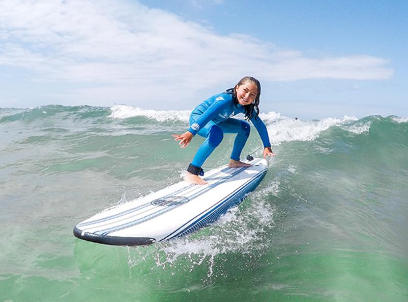 niña practicando surf en el campamento de surf en Cantabria