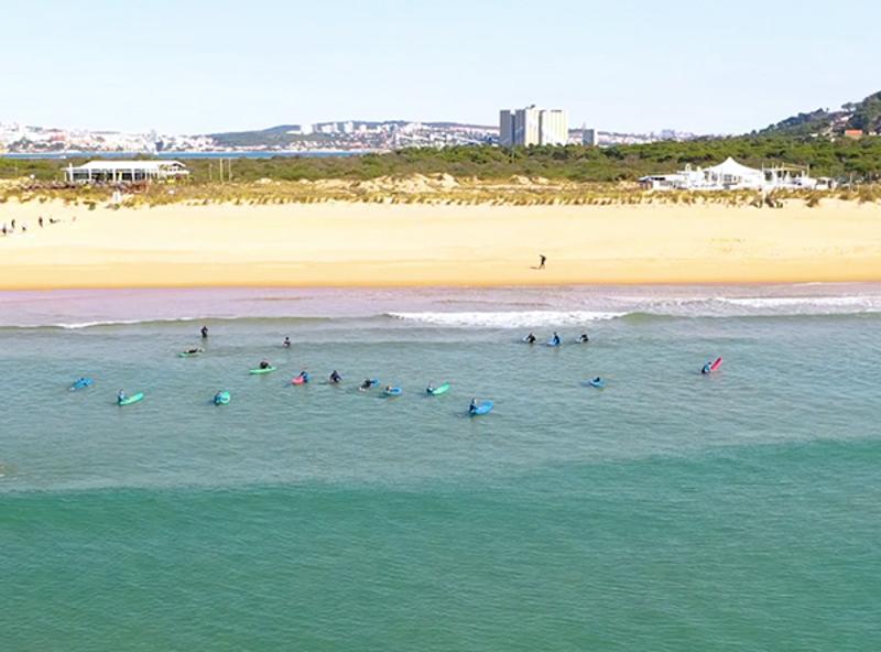 grupo de jovenes haciendo surf en la playa de campamento de verano en portugal