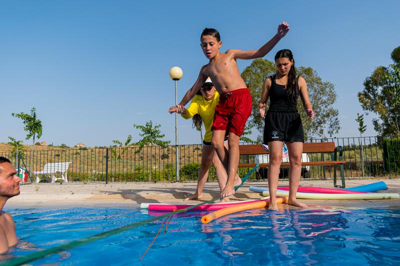 niños disfrutando de una tarde de actividades acuáticas en la piscina del campamento castilla y leon