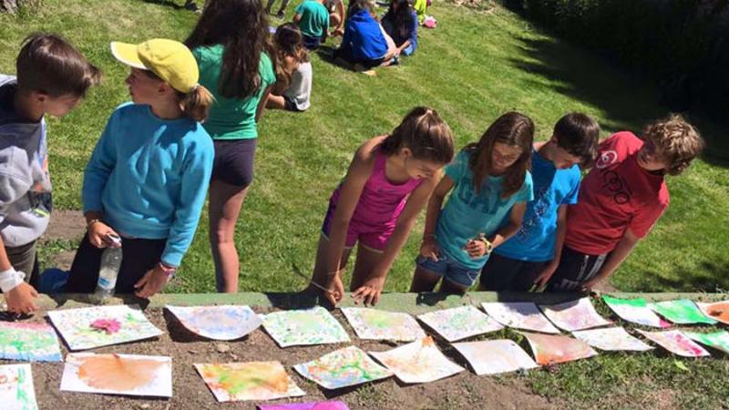 Grupo de niños observando los resultados de sus dibujos realizados en una de las clases del campamento francés