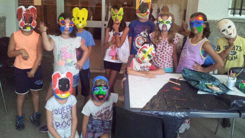 Grupo de niños disfrutando de una fiesta de mascaras en las clases creativas del campamento de verano en Marbella