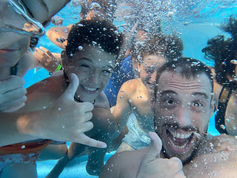 un grupo de niños en una piscina sumergidos en el agua en unas vacaciones deportivas españa