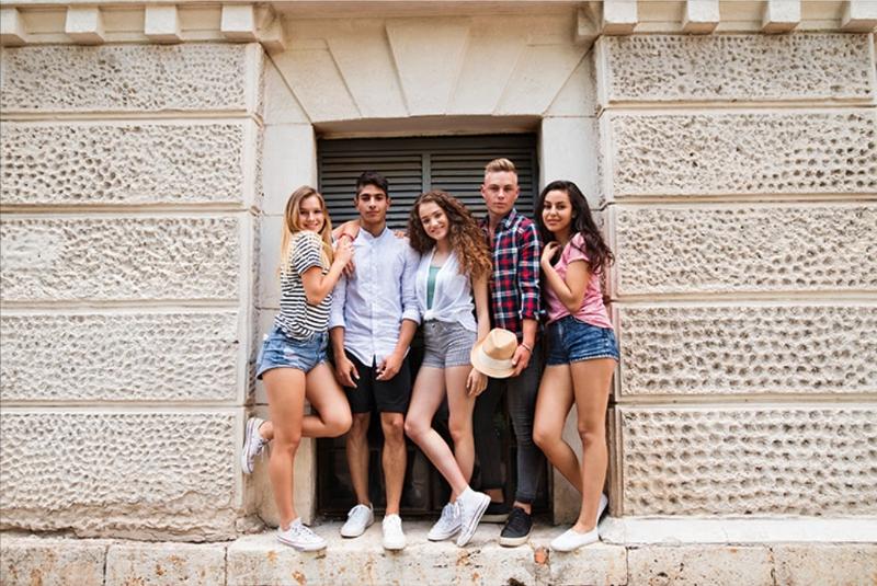 grupo de jóvenes posando en un muro en el campamento de verano julio