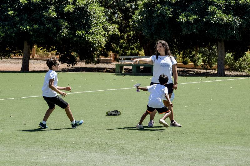 niños practicando juegos en la cancha de fútbol del campamento de verano infantil
