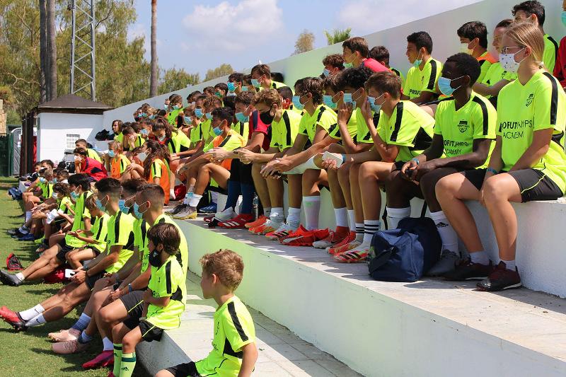 Grupo de jóvenes atendiendo a las indicaciones del entrenador durante el campus navidad fútbol