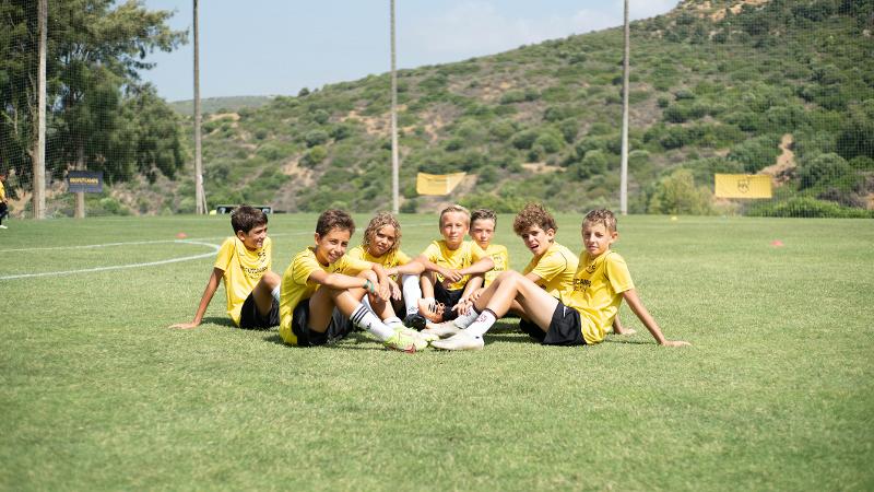 Chicos sentados en el césped en el summer camp marbella