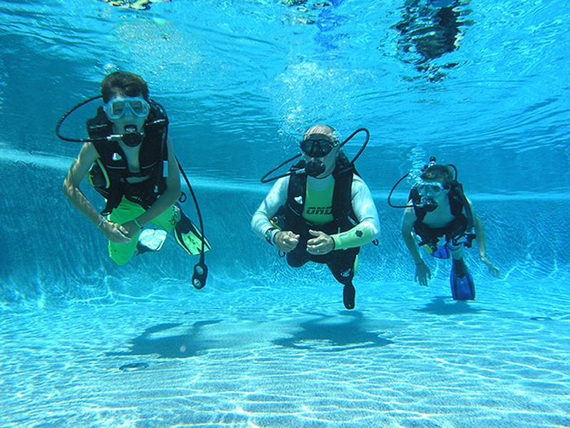 niñas practicando buceo en la piscina del campamento de verano en portugal