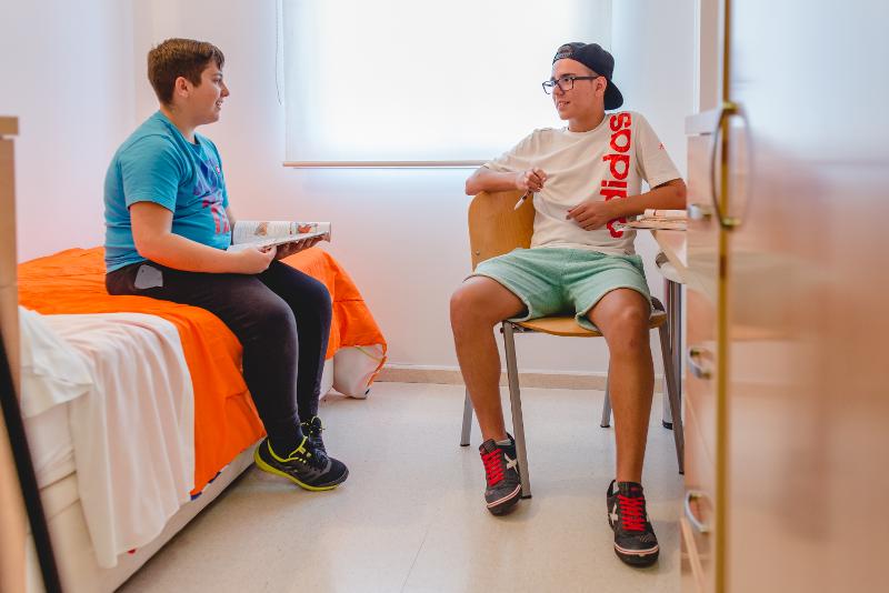 dos niños conversando en la habitación individual de la residencia de su viaje de idiomas al extranjero