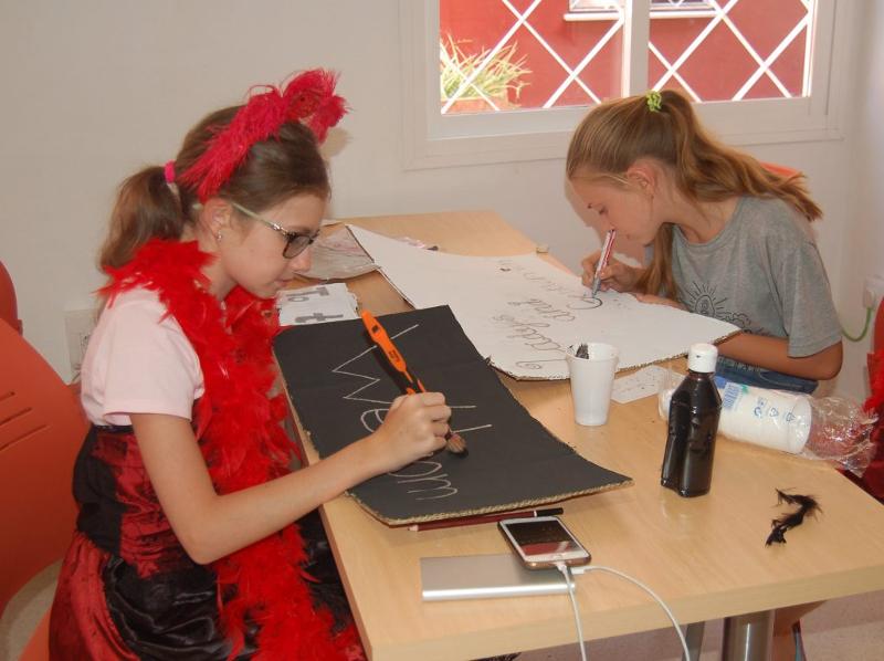 Niñas en el campamento de Navidad haciendo manualidades navideñas