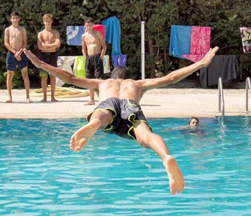Joven lanzándose a la piscina en uno de los juegos del campamento de verano en Madrid