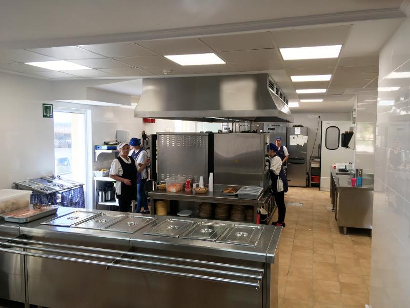 Equipo del campamento de verano en Madrid preparando la comida en la cocina de las instalaciones