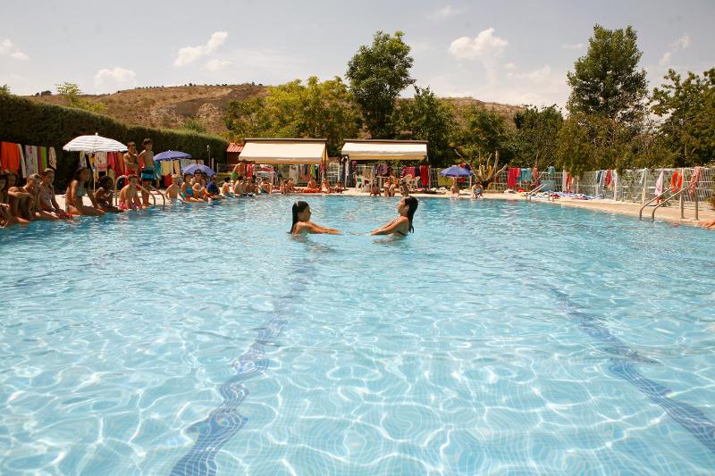 Participantes del campamento waterpolo haciendo ejercicios de fuerza en la piscina para mejorar la técnica