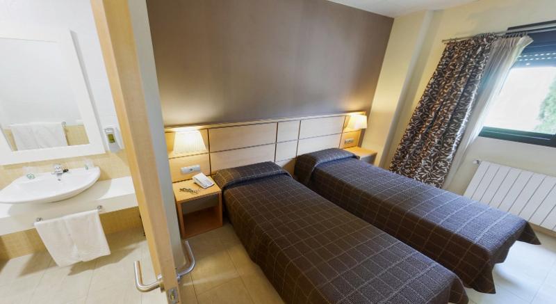 Habitación con camas individuales y baño privado en el campamento de verano en Valencia