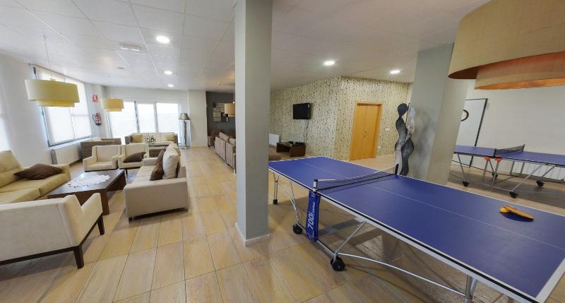 Zona recreativa con sofás y mesas de ping pong para los momentos libres del campamento de fútbol en Valencia