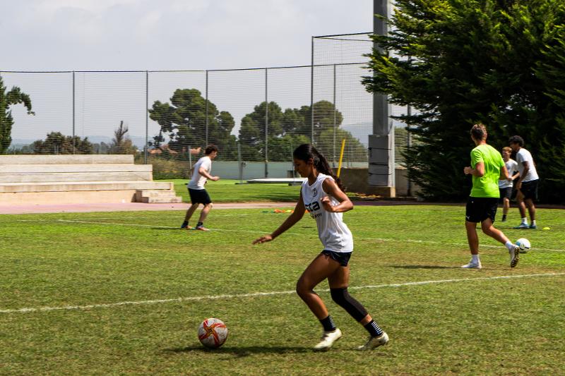 Chica conduciendo el balón en un campamento de futbol