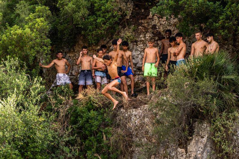 Niño saltando al agua en un campamento de futbol 