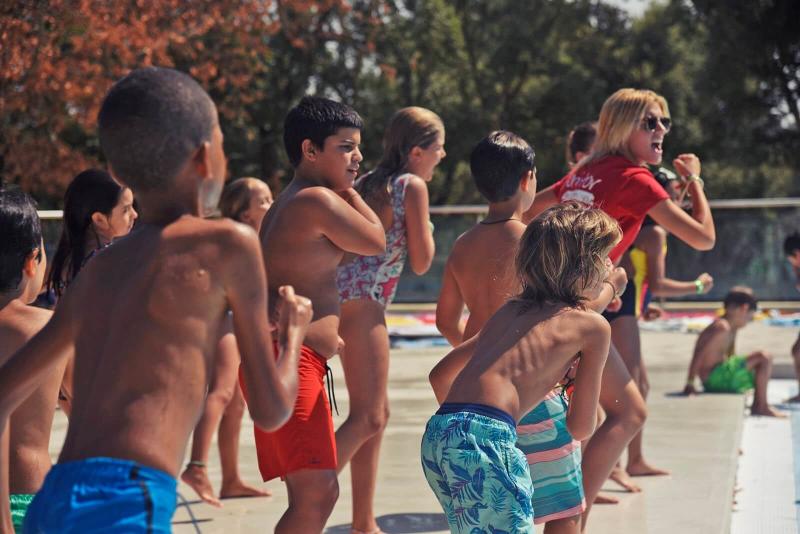 Chicos disfrutando de las actividades en la piscina en el campamento de inglés en el extranjero