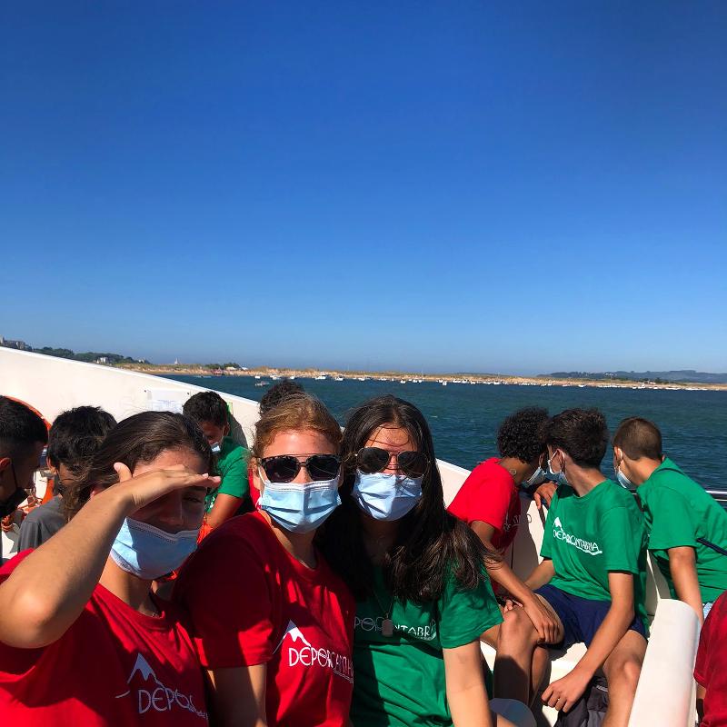 Adolescentes en un barco durante un surfcamp cantabria