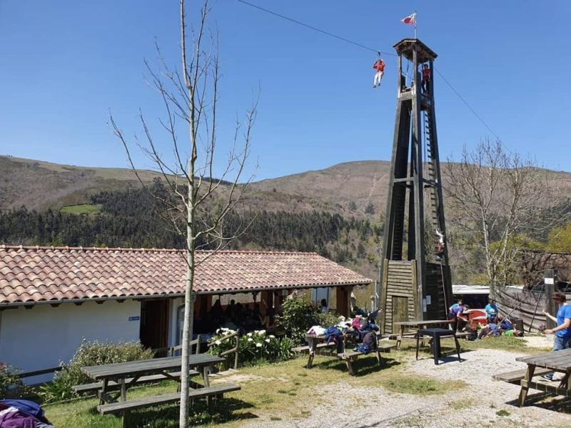 Vista de un niño lanzándose en tirolina en las instalaciones montadas en el campamento multiaventura en Cantabria