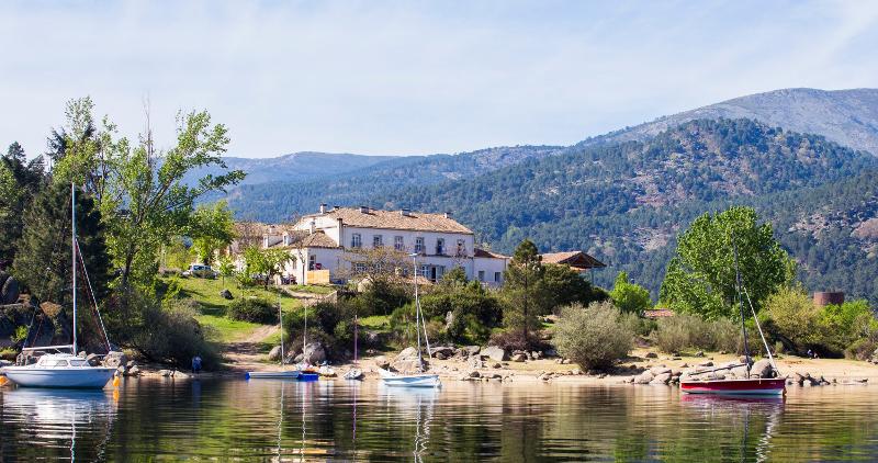 Vista externa de la casa del campamento vela y las barcas atracadas en el embalse